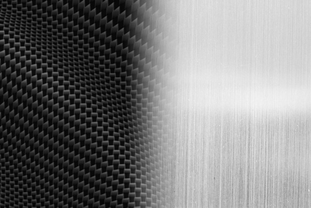 A close-up view of carbon fiber and brushed aluminum textures, showcasing the materials used in Onyx Mount's products.